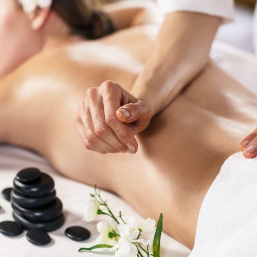 Young beautiful woman enjoying massage on the table at spa center
